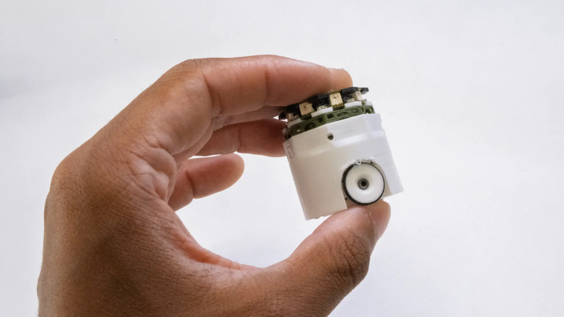 A hand shaking one robot between finger and thumb.
