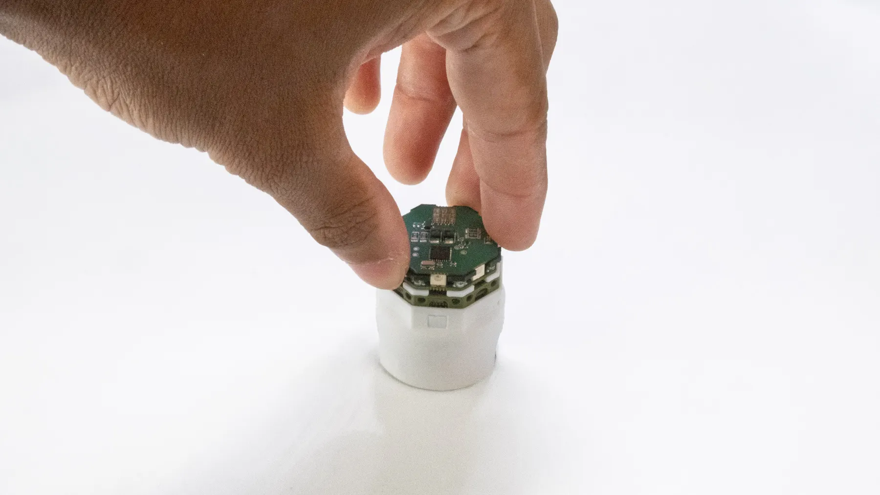 Fingers twisting the top of a single robot.