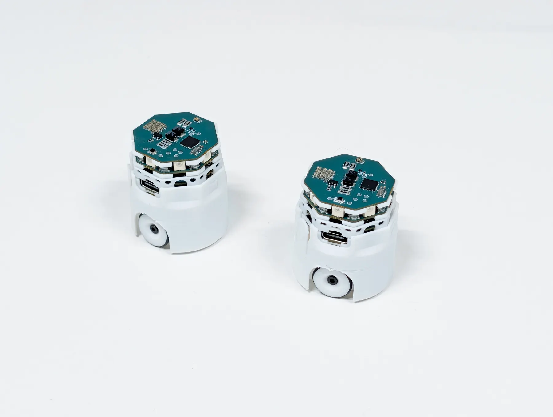 Two robots facing each other on a white table.